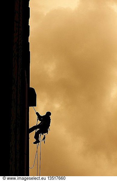 Man climbing on a house front