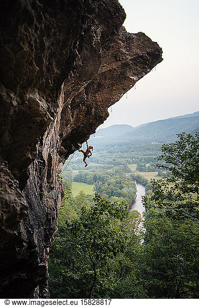 Man climbing overhanging sport climbing route in New Hampshire