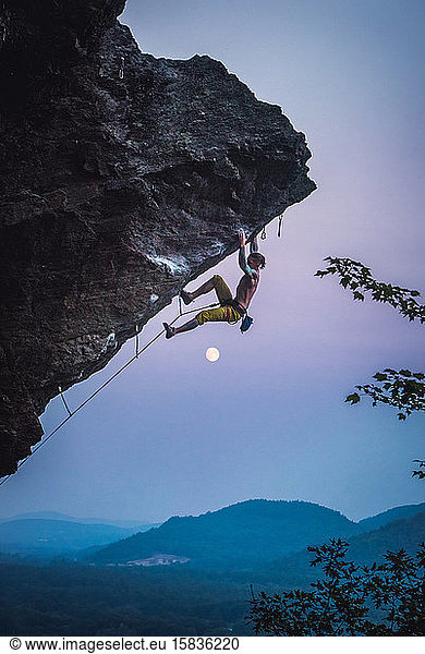 Man climbing overhanging sport climbing route in New Hampshire