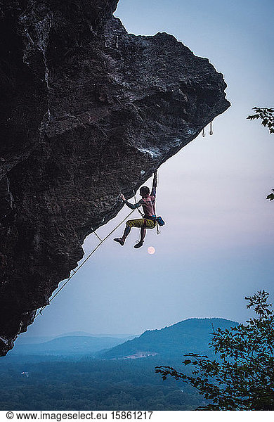 Man climbing overhanging sport climbing route in New Hampshire