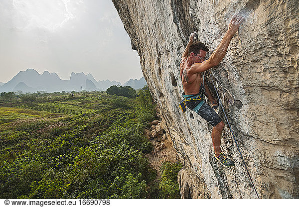 man climbing rock face in Yangshuo / China