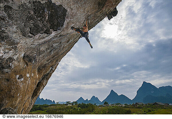 Man climbing steep overhang in Yangshuo / China