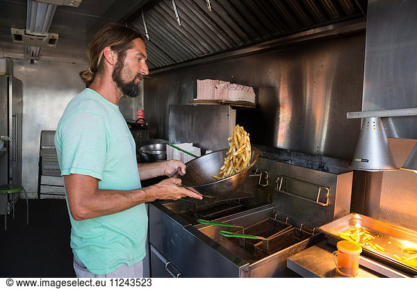 Man cooking food in fast food trailer