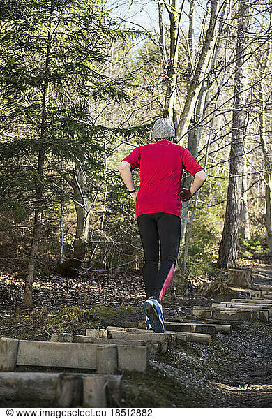 Man doing exercise at obstacle course on fitness trail in forest
