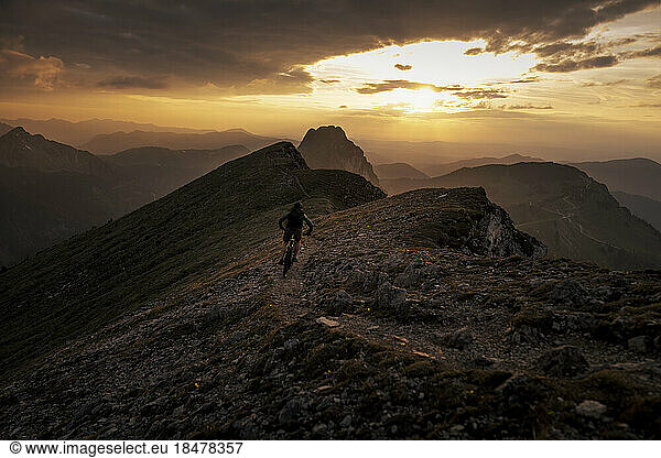 Man doing mountain biking at sunset