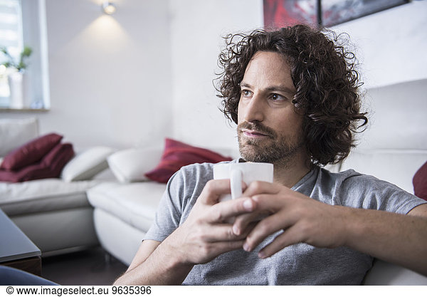 Man drinking cup of coffee at home
