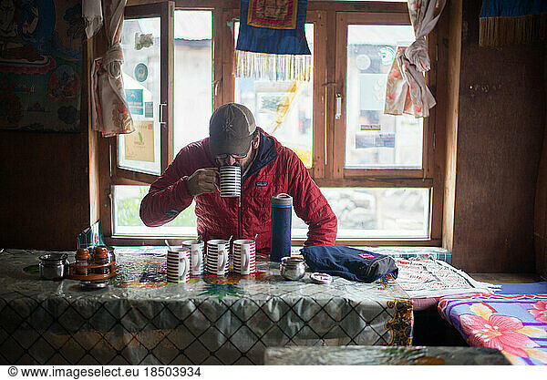 Man drinking tea in village town in Himalayan Mountains