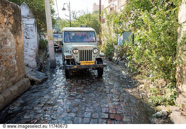 Man driving a Jeep on a street in Jaipur  India.