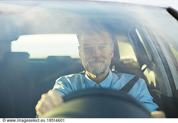 Man driving car seen through windshield