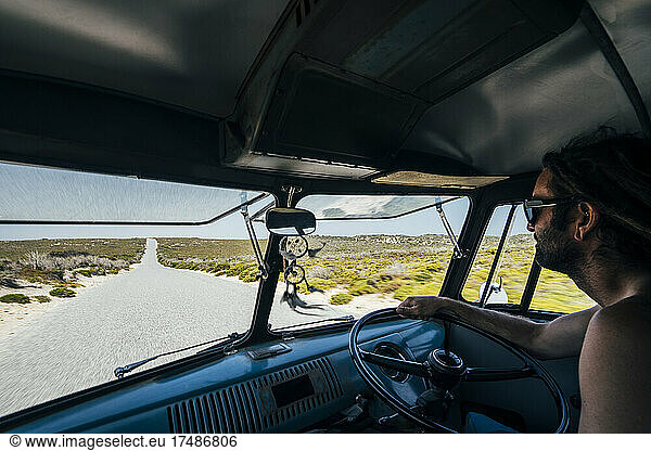Man driving van on remote road in Australian bush