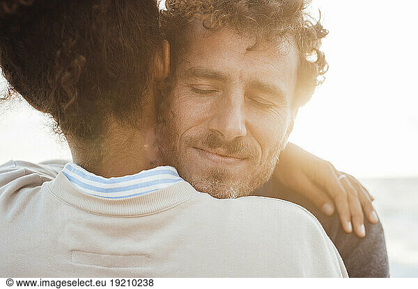 Man embracing girlfriend at beach
