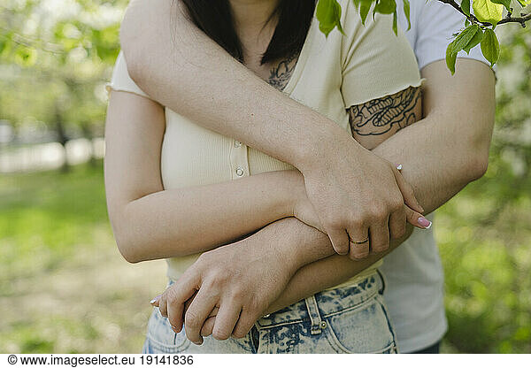 Man embracing girlfriend at park