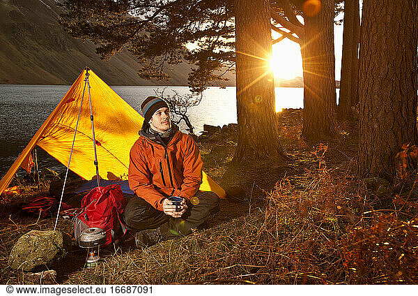 man enjoying hot drink at simple camp in the British Lake district
