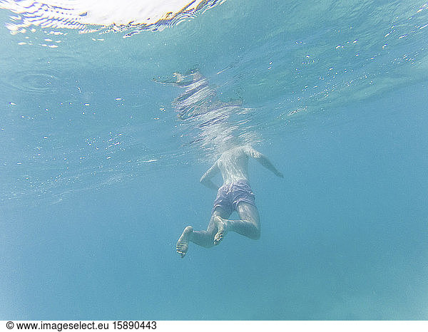 Man floating in water  underwater view