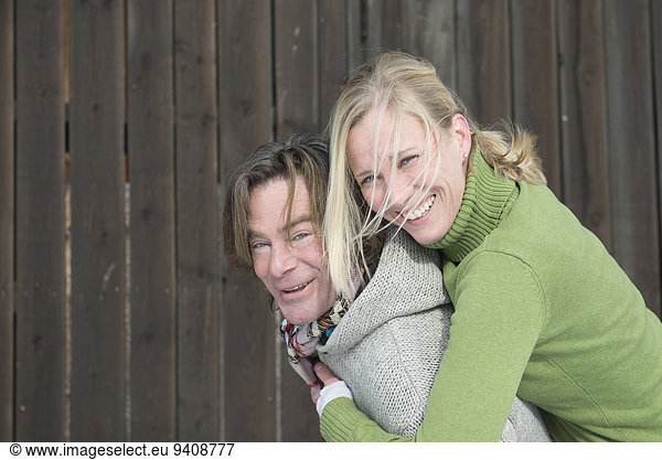 Man giving piggyback ride to woman  smiling