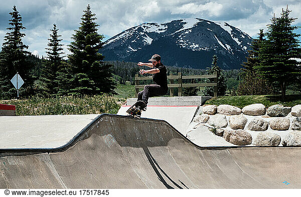 Man 5-0 Grinding Across Ramp at Skatepark in Mountains in Colorado