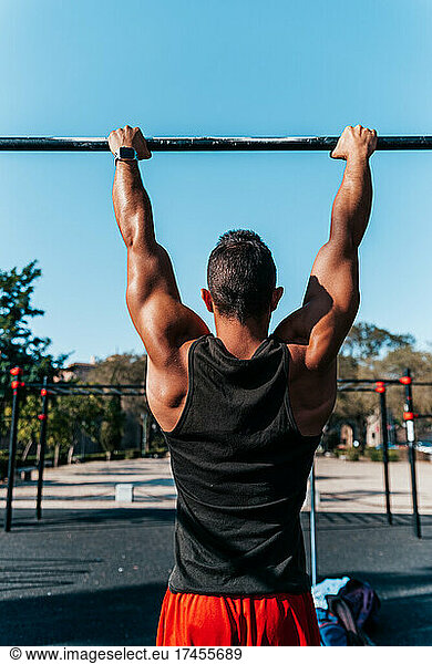 Man hanging from a pull-up bar