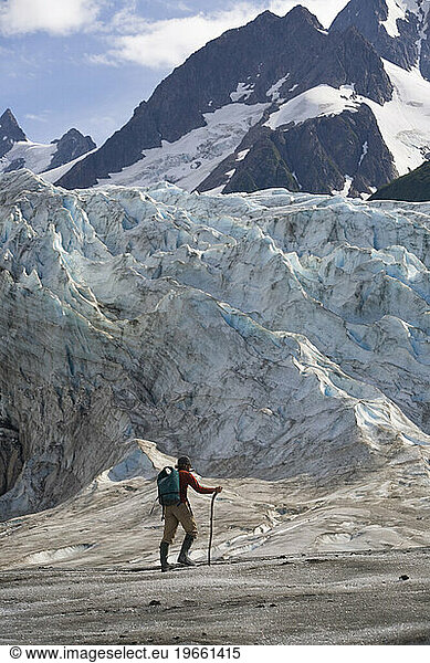 Man hiking across a glacier in Alaska  United States.
