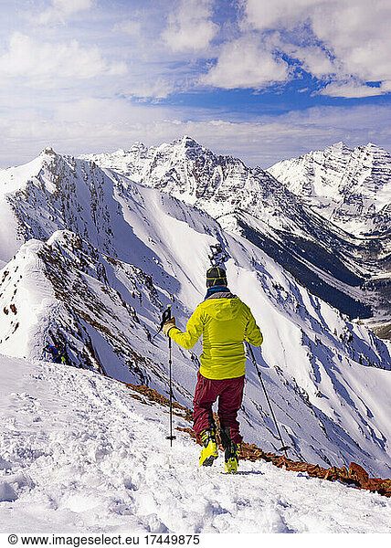 Man Hiking On Summit Mountain Peak In Epic Extreme Winter Landscape