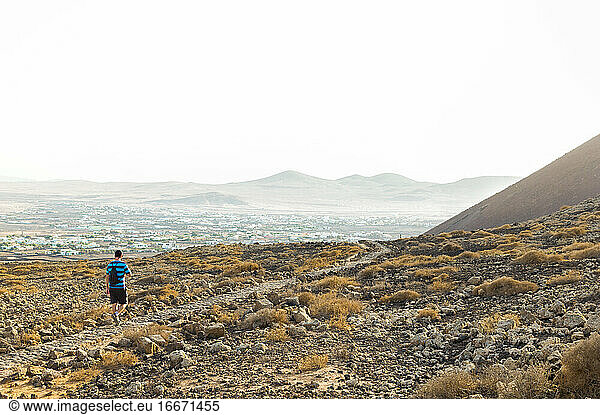 Man hiking through mountainous and desert landscape of Fuerteventura