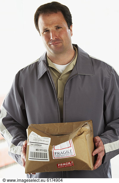 Man holding crushed package marked Fragile