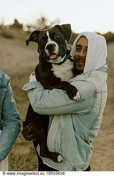 Man holding dog like its his child both are smiling