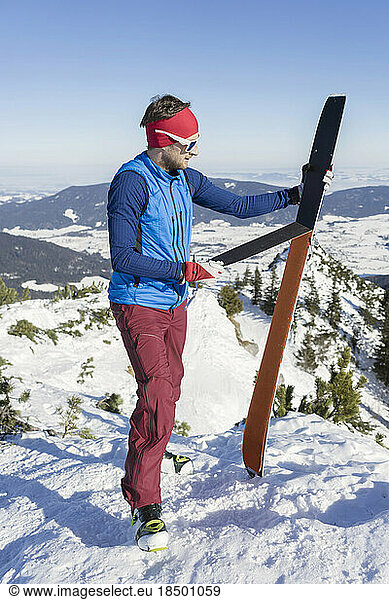 Man holding skis on mountain