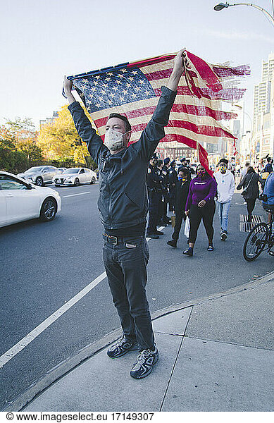 Man holding up American Flag during Celebration of President-Elect Joe Biden  Brooklyn  New York  USA