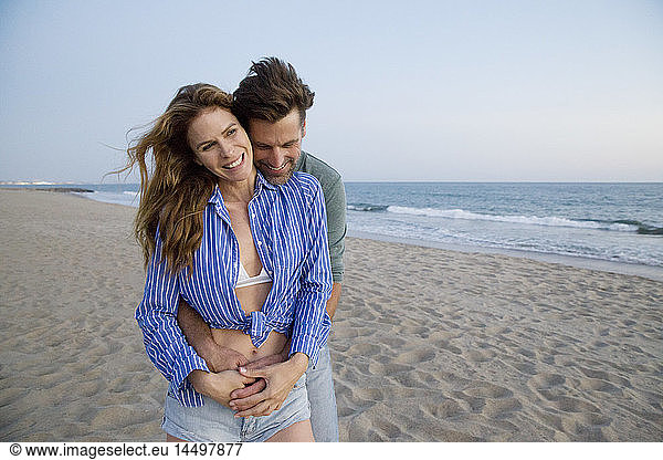 Man Hugging Woman from Behind at Beach