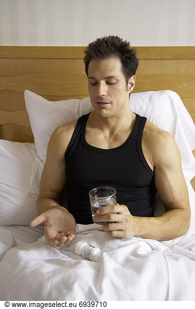 Man in Bed  Taking Pills