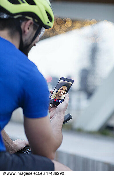 Man in bike helmet video chatting with girlfriend