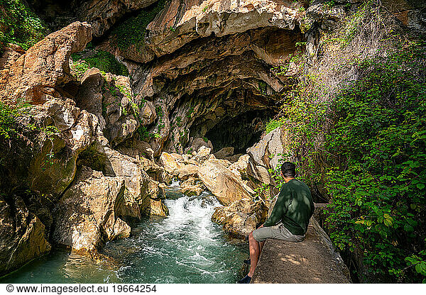 Man in Cueva del Gato cave with a waterfall in Andalusia  Spain