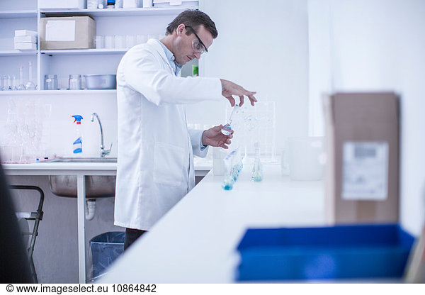 Man in laboratory  tightening lid on test tube  close-up