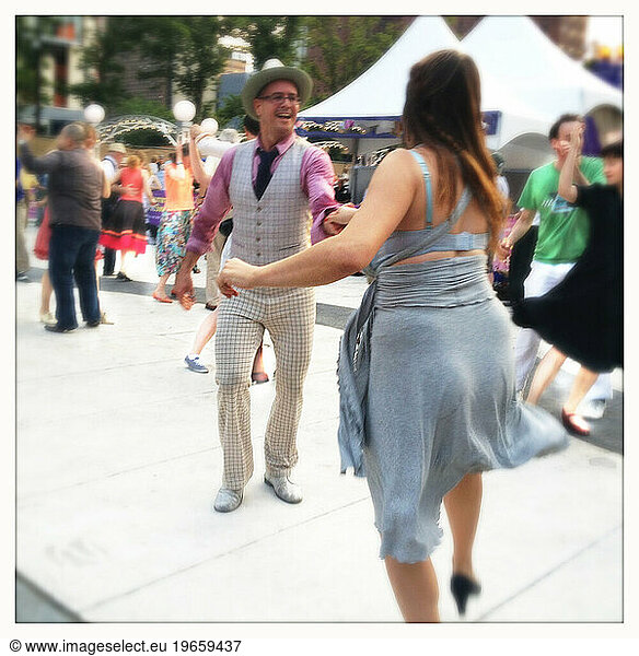 Man in light Checkered Suit Dancing the Boogie Woogie with Woman in Blue