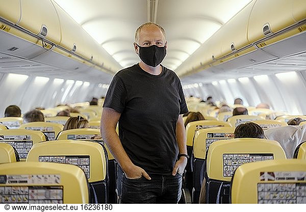 Man in protective mask standing in airplane  Portugal  Europe