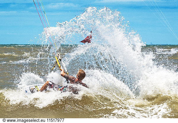 Man in sea kite surfing  splashing