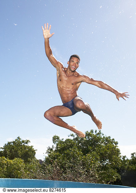 Man in swim trunks jumping