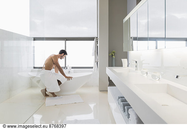 Man in towel preparing bath