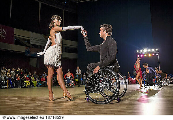 Man In Wheelchair Performing Dance With His Partner During A Competition In Russia