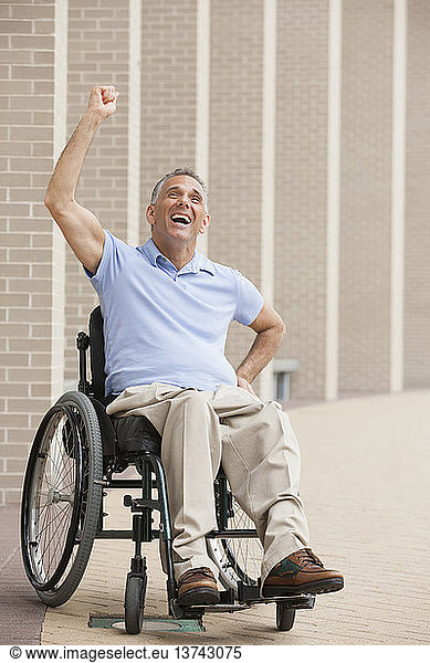 Man in wheelchair with spinal cord injury cheering