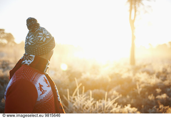 Man in winter clothes, looking at rural scene