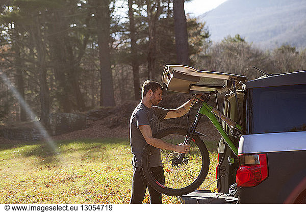 Man keeping mountain bike in car trunk