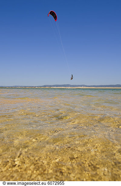 Man kite surfing over sea