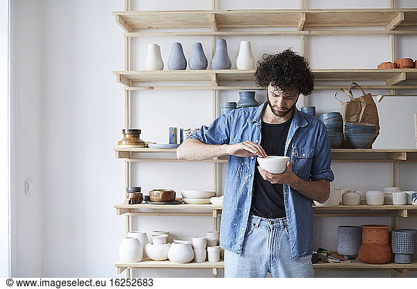Man learning pottery in art studio