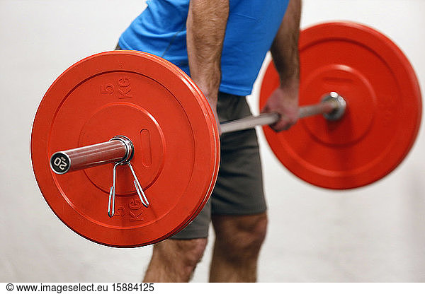 Man lifting weights in gym. France.