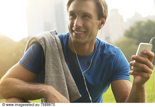 Man listening to mp3 player in park
