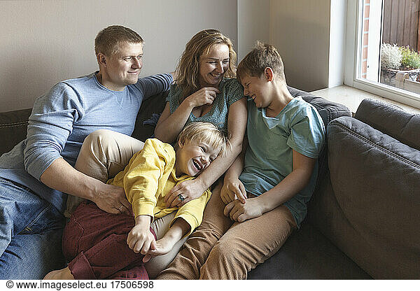 Man looking at family laughing on sofa
