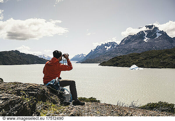 Man looking at Grey Glacier with binocular at Torres Del Paine National Park  Patagonia  Chile  South America