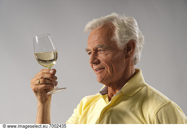Man Looking at Wine in Glass