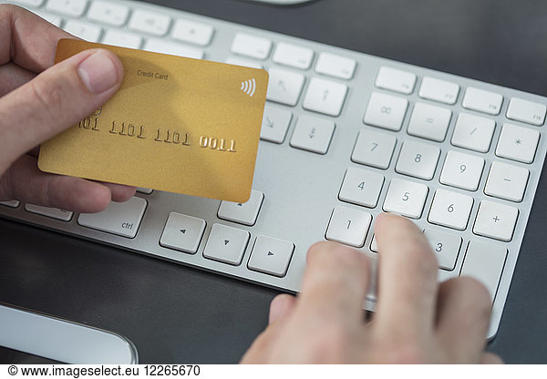Man making online payment with credit card at desk  close-up